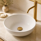 Válvula click dourado escovado instalada em cuba branca de lavabo