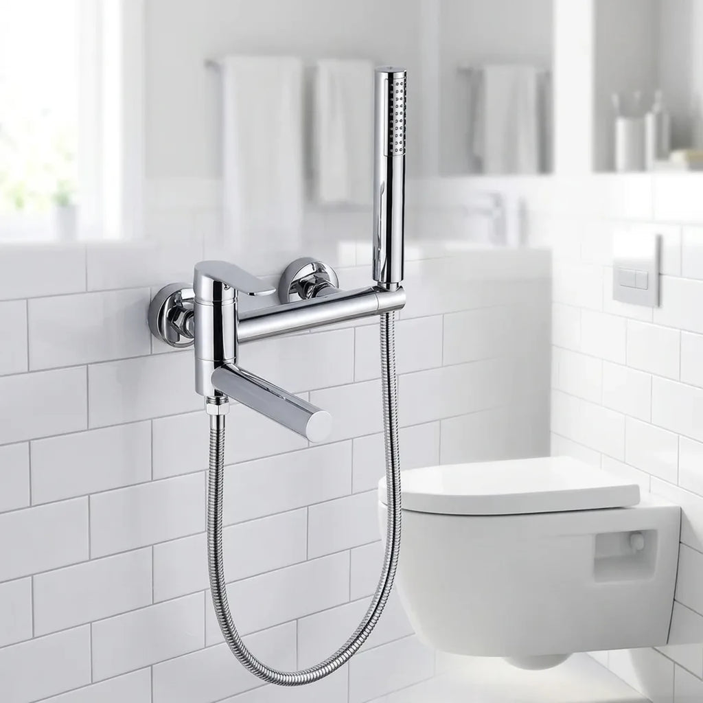 Ducha higiênica Royal Concept cromada instalada em banheiro branco claro ao lado do vaso sanitário