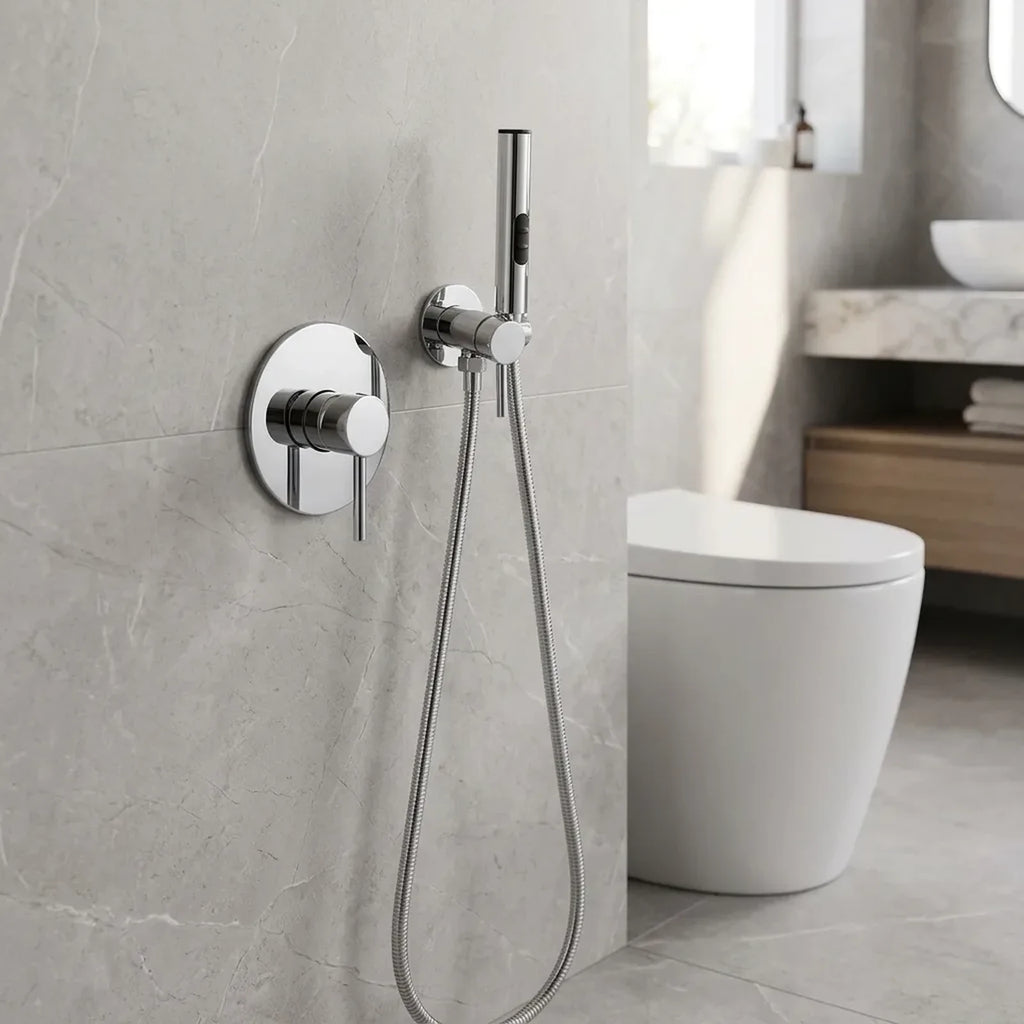 Ducha higiênica Royal Orion cromada instalada em parede de porcelanato cinza ao lado do vaso sanitário