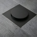 Ralo click inteligente 15x15 cm preto fosco instalado em piso de porcelanato cinza, com tampa redonda