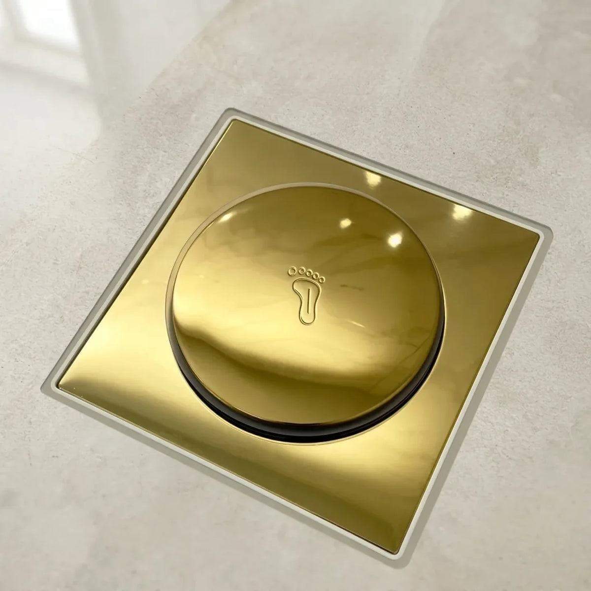 Ralo click inteligente quadrado dourado instalado em piso de porcelanato, com tampa redonda e vedacao veda cheiro