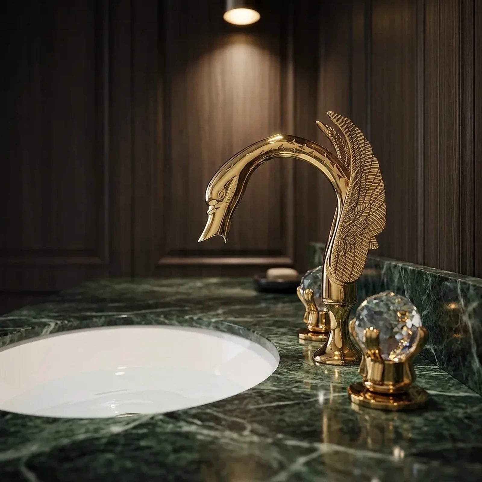Torneira dourada modelo cisne com manoplas de cristal em bancada de mármore verde e banheiro contemporâneo