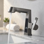 Torneira com display digital pull-out preto fosco instalada em bancada de mármore claro, display mostrando 38°C e água corrente
