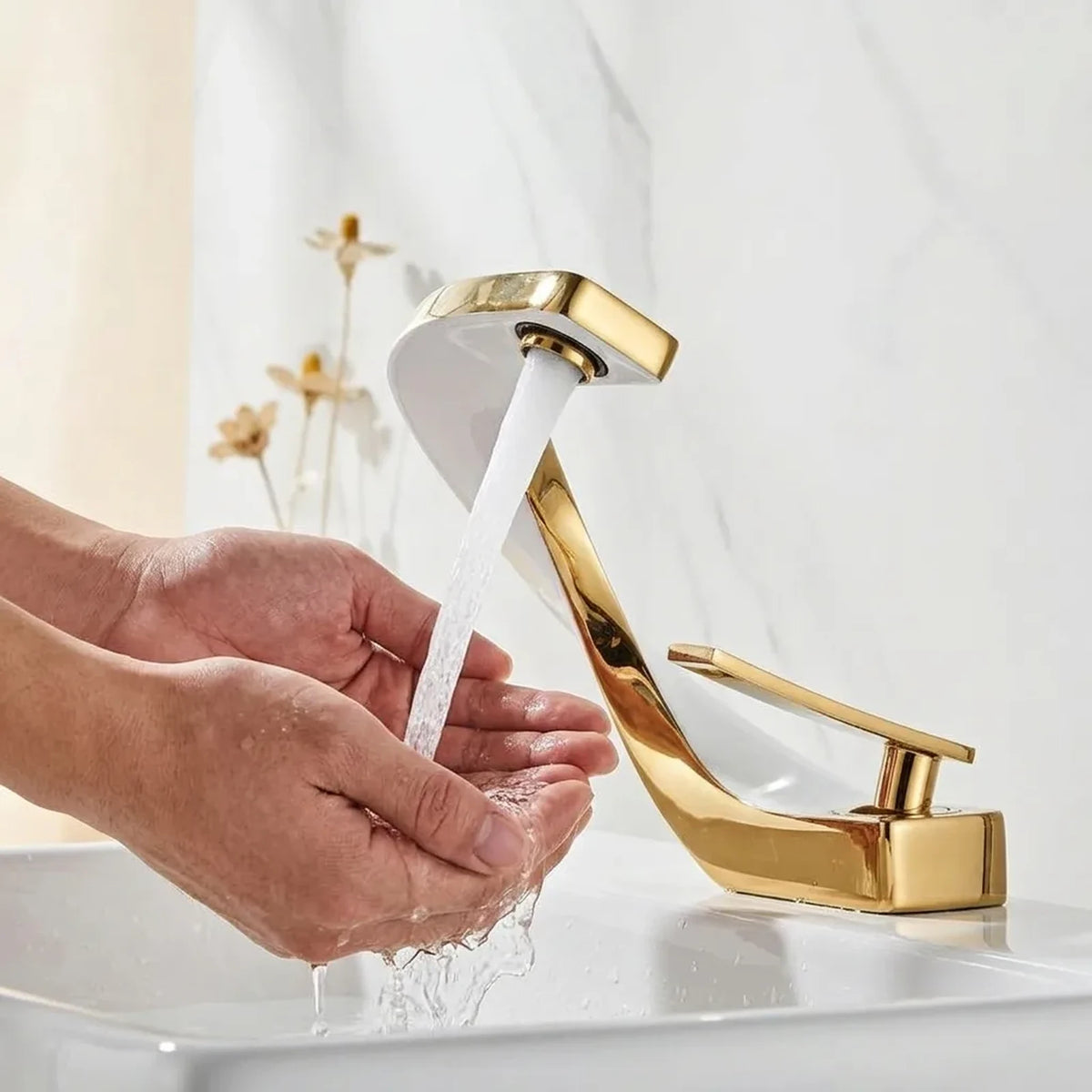 Mãos sendo lavadas sob o jato da torneira gourmet monocomando AquaElite branca com detalhes dourados em cuba de banheiro