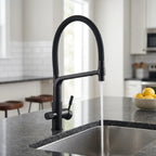 Torneira gourmet com filtro Luxflow preta instalada em ilha de cozinha com bancada de granito escuro