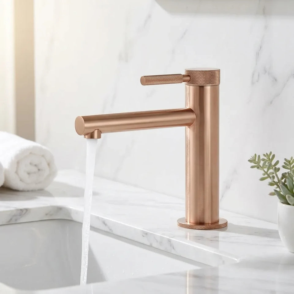 Torneira monocomando rose gold com detalhes serrilhados instalada em bancada de mármore branco