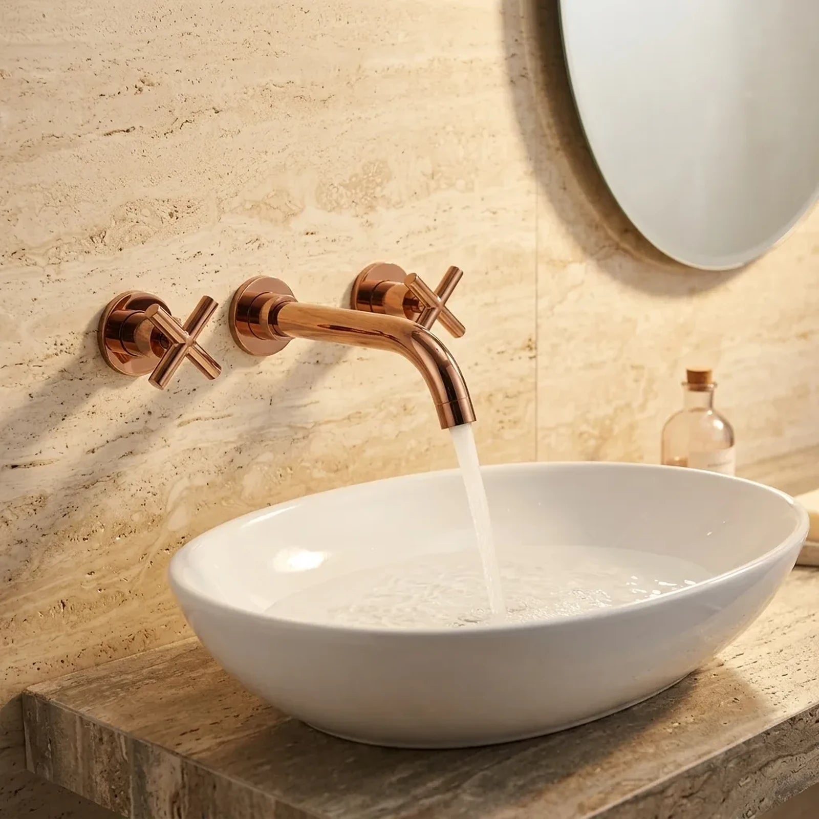 Torneira de parede Royal Serena rose gold em parede de travertino com cuba oval