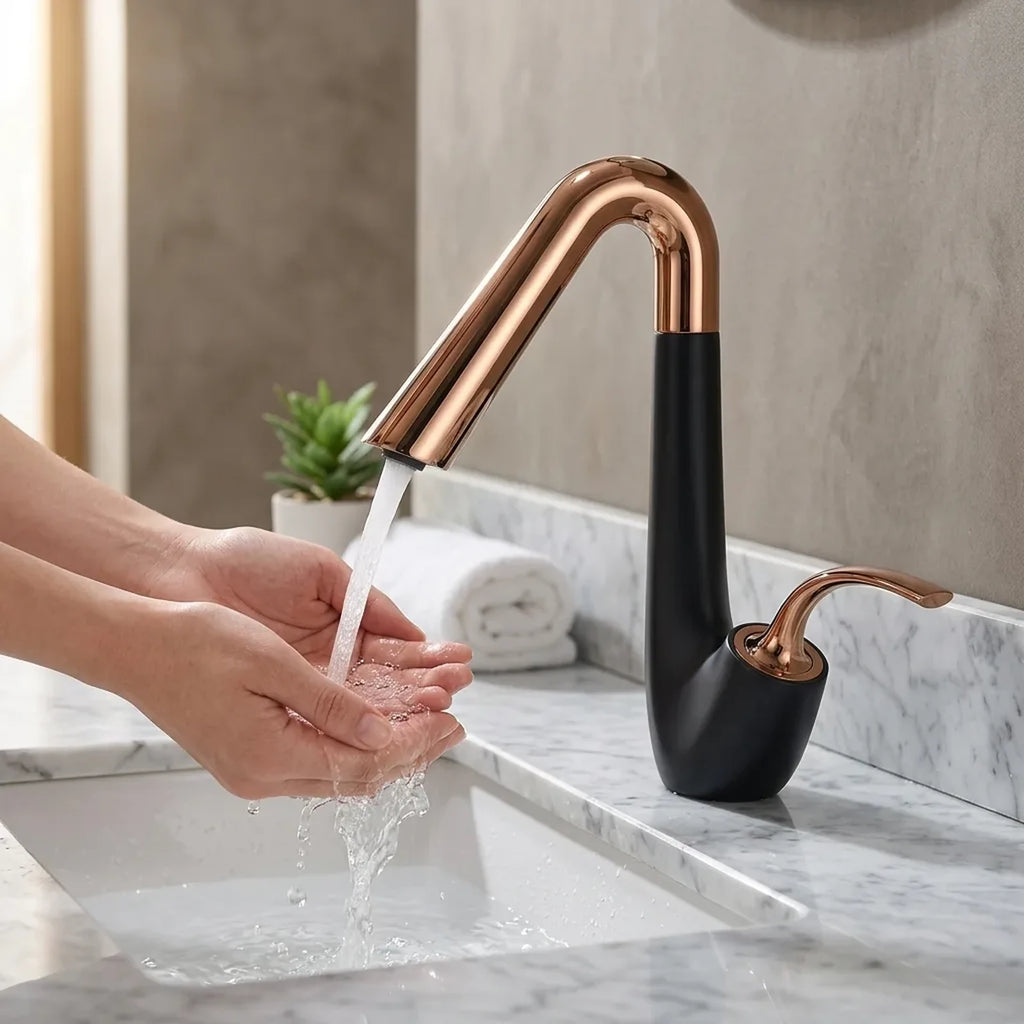 Torneira Platine preto com rose gold em uso, mãos sob o jato de água na bancada de mármore