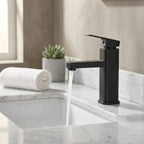 Torneira PureStream Preto ambientada em banheiro com bancada de mármore branco