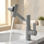 Torneira monocomando com sensor de temperatura cinza instalada em bancada de mármore branco com cuba de banheiro
